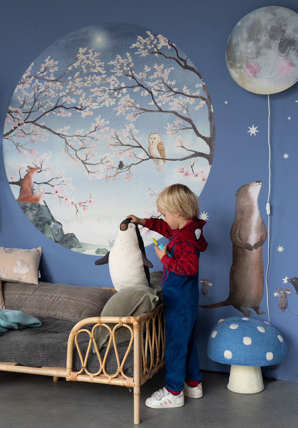 Bloesem behangcirkel S van Hartendief op een blauwe muur met een spelend kind