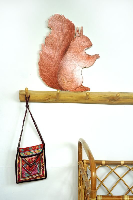 Hartendief Eekhoorntje muursticker boven kapstokje met tasje op witte muur met bamboe kinderbedje – lieve bosdieren wanddecoratie kinderkamer