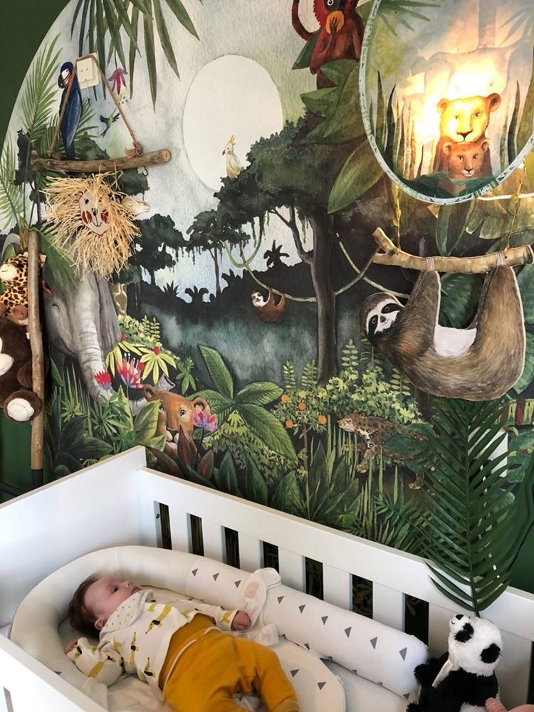 Jungle behangcirkel van Hartendief in een babykamer met een baby in een wit bedje