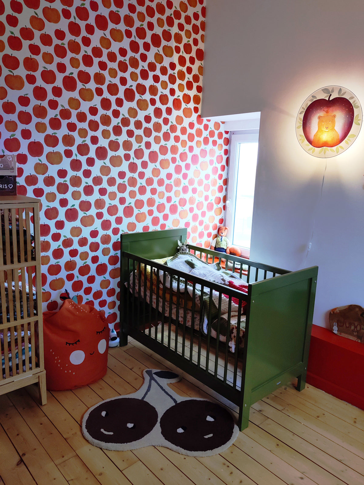 Funky Apples nursery wallpaper by Hartendief in a kids' room with the Bear in the Apple wall lamp and a green cot