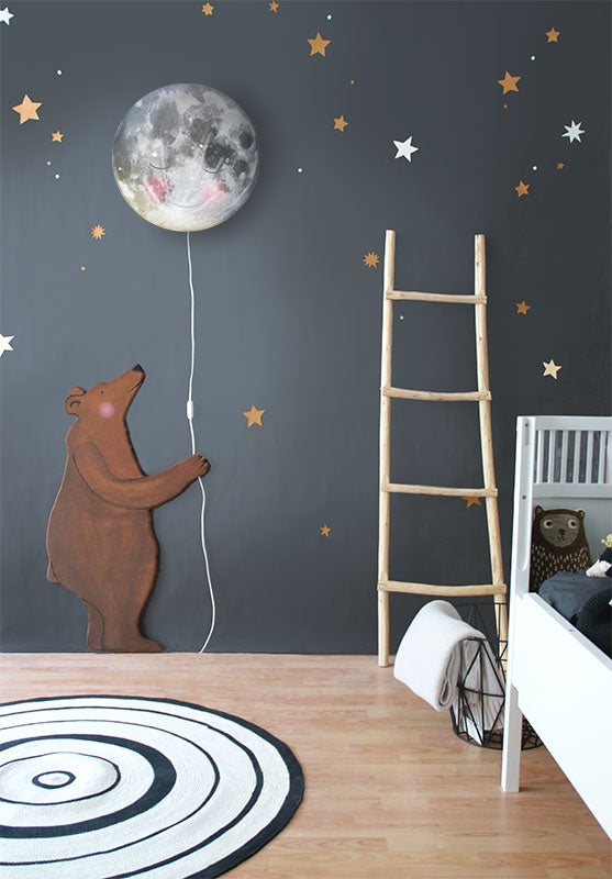 Sleepy Moon wall lamp by Hartendief on a dark grey wall with the Bear wall decal, gold and white stars and a wooden ladder