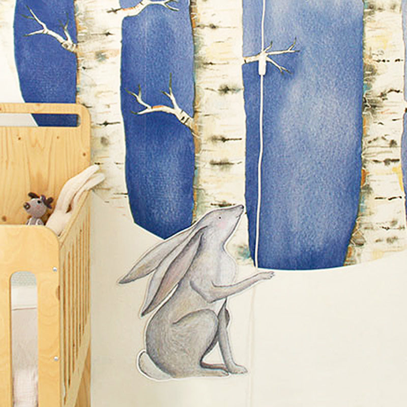 Close-up van Haasje Repje muursticker naast Oogjes Toe wandlamp boven een houten babybedje