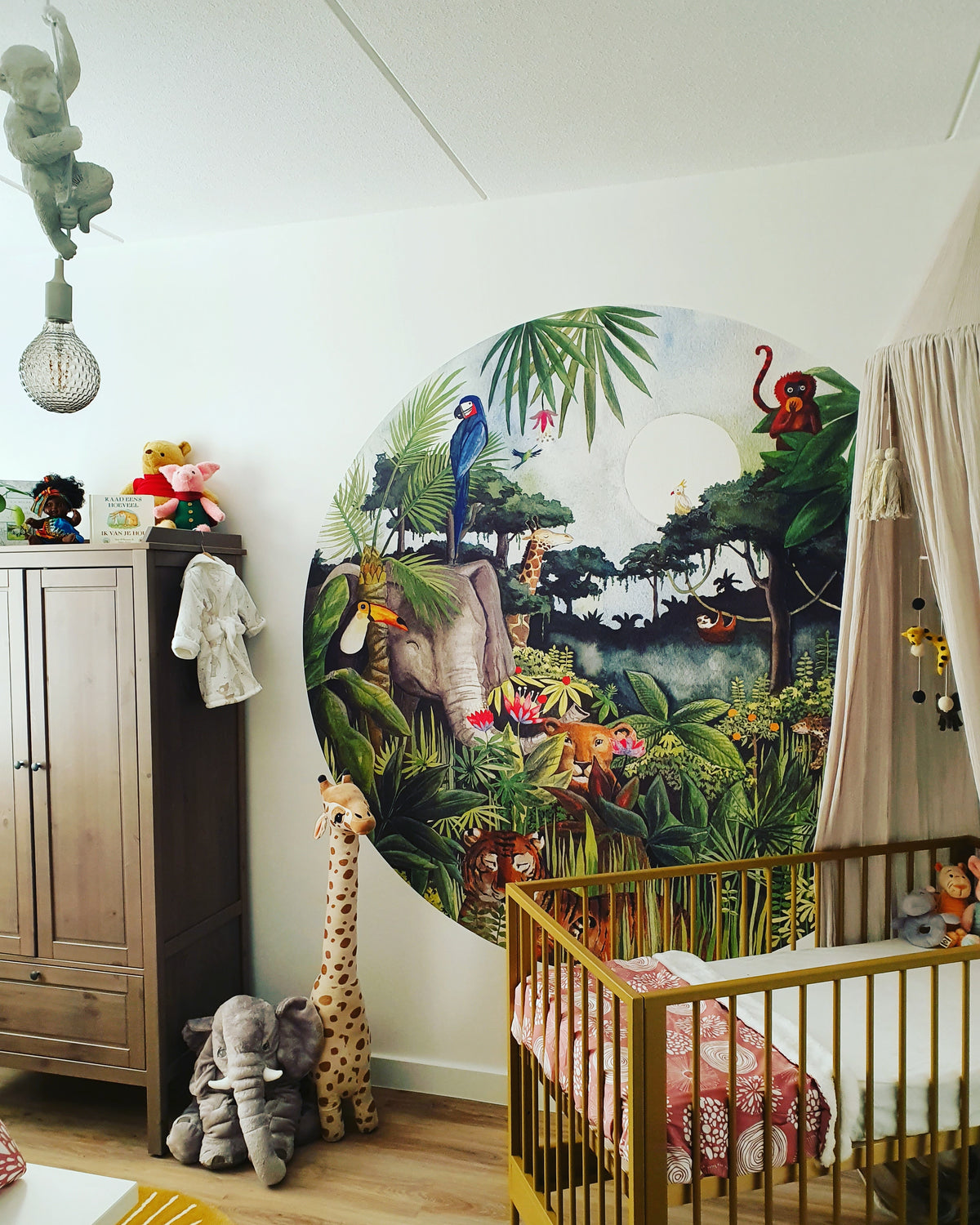 Jungle behangcirkel van Hartendief in een neutrale babykamer met bedhemeltje
