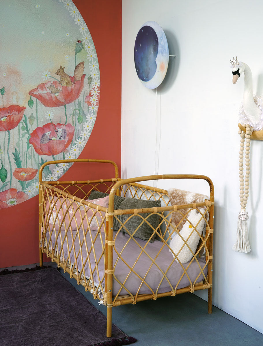 Klaprozendroom behangcirkel van Hartendief in een babykamer met rotan bedje en de Oogjes Toe wandlamp