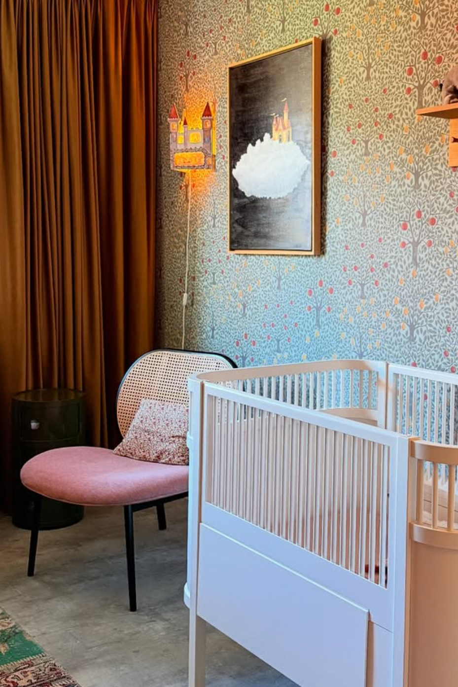 Muizenkasteel lamp van Hartendief brandend in een babykamer met okergele gordijnen, bloemenbehang en wiegje