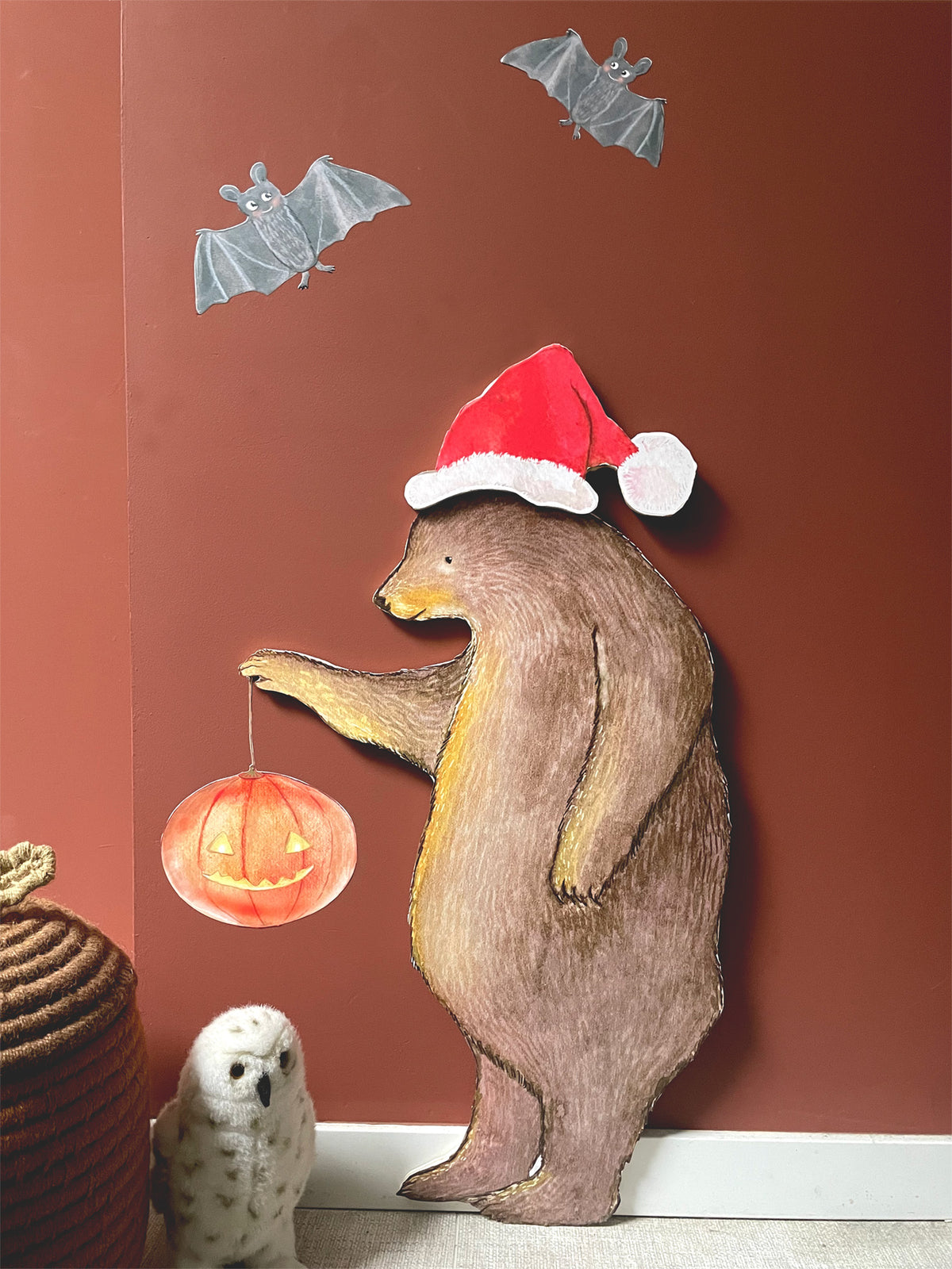 Night Bear wall decal with Santa hat and pumpkin lantern on a terracotta wall, with bats and a cuddly owl – swappable hat for Christmas