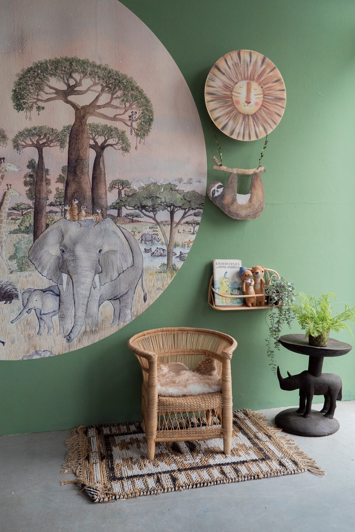 Savanne L behangcirkel van Hartendief op een lichtgroene muur met rotan stoeltje, leesplankje en de Sunny de Leeuw wandlamp