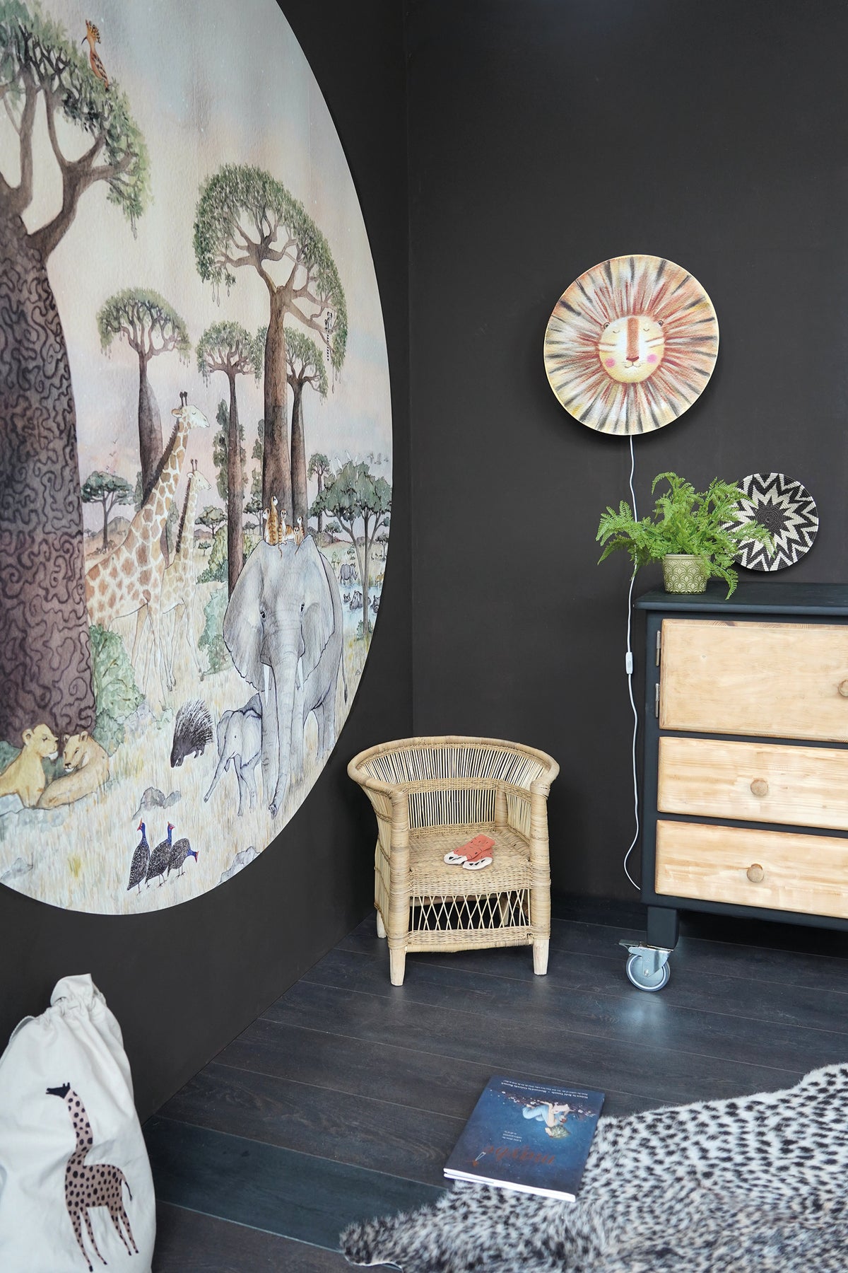 Savanne behangcirkel S van Hartendief op een donkere kinderkamermuur met de Sunny de Leeuw wandlamp – complete safari kinderkamer in warme zandtinten